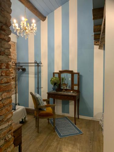 a room with a table and a chair and a mirror at Il Giardino Segreto Arona, Charming Apartments in Arona