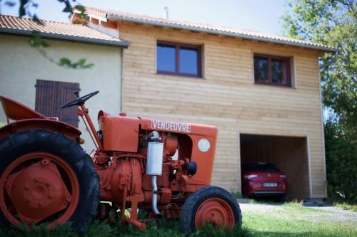 a red tractor parked in front of a house at Gîte la ferme de Baffour in La Chaise-Dieu