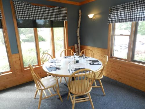 a dining room with a table and chairs and windows at C-Way Resort in Clayton