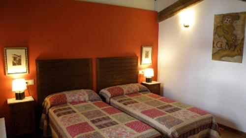 a bedroom with a bed and two lamps in it at Amaiurko Errota in Maya del Baztán