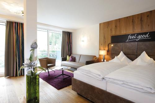 a bedroom with a large bed and a living room at Hotel Fliana Ischgl in Ischgl