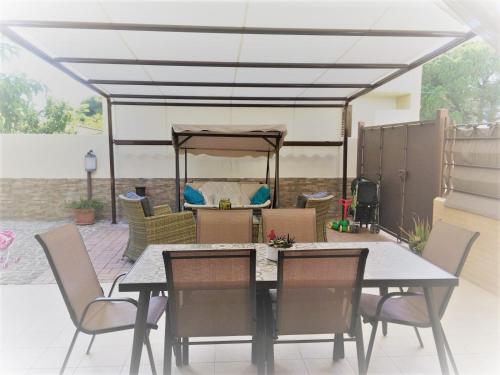 un patio con tavolo, sedie e tenda di Home Sweet Home a Pulsano