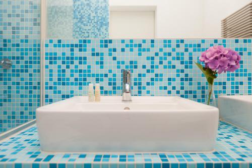 a bathroom with a sink and a vase of flowers at Gutshaus Lexow in Lexow