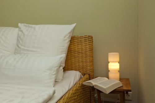 a bed with a pillow and a table with a book at Gutshaus Lexow in Lexow