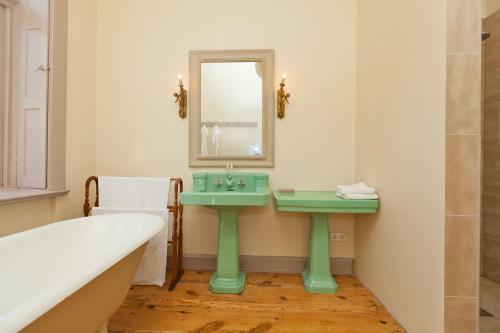 a bathroom with a green sink and a bath tub at Gutshaus Lexow in Lexow