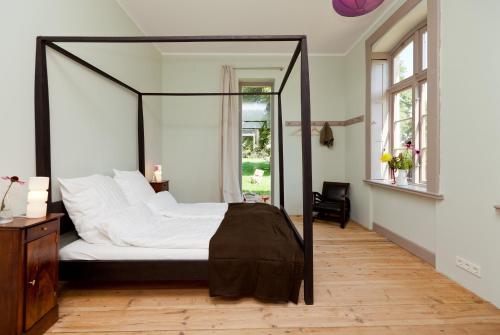 a bedroom with a canopy bed with white pillows at Gutshaus Lexow in Lexow
