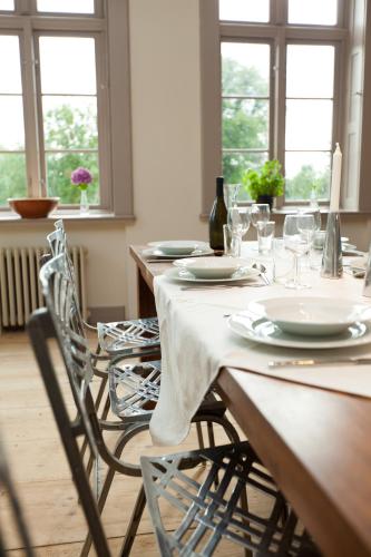 a dining room with a table with plates and wine glasses at Gutshaus Lexow in Lexow