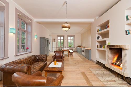 a living room with a couch and a fireplace at Gutshaus Lexow in Lexow