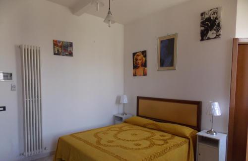 1 dormitorio con 1 cama y algunas fotos en la pared en Il Gatto Con Gli Stivali, en Florencia