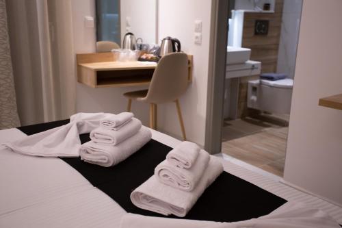 pokój hotelowy z białymi ręcznikami na łóżku w obiekcie Marvel Deluxe Rooms w Heraklionie