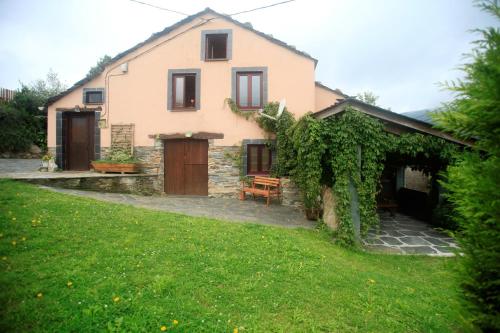 ein Haus mit einem grünen Garten davor in der Unterkunft Vivienda Vacacional Bioxana in Molejón