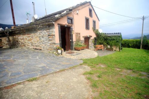 ein kleines Steinhaus mit einer Steinzufahrt in der Unterkunft Vivienda Vacacional Bioxana in Molejón