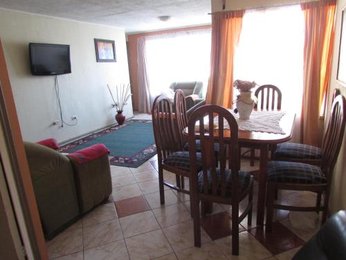 a living room with a table and chairs and a couch at Cabaña la villa in Frutillar