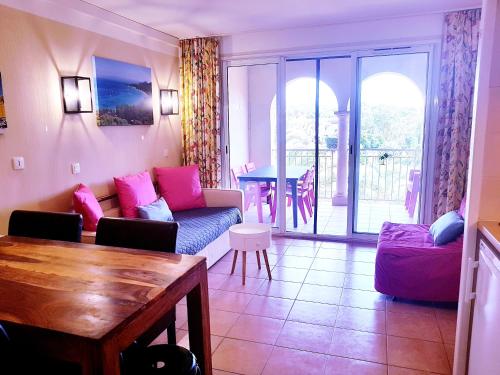 un salon avec un canapé et une table dans l'établissement Les Ecrins de la Badine - hameaux, à Hyères
