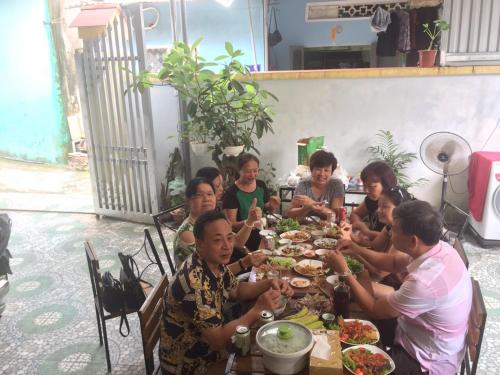 a group of people sitting at a table eating food at Cat Ba Mystery Homestay in Cat Ba