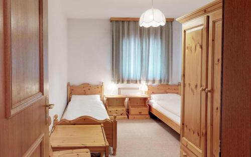 una piccola camera con due letti e una finestra di Ludains 6 a Sankt Moritz