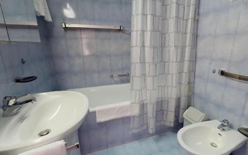 bagno con lavandino, vasca e servizi igienici di Ludains 6 a Sankt Moritz