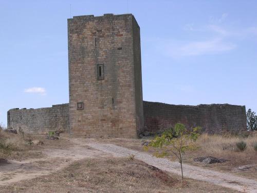 a tall brick building on a dirt road at Casas da Lagariça in Sortelha