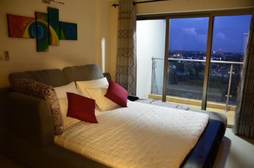 1 dormitorio con cama y ventana grande en Atrium - ICONIC APARTMENT en Sri Jayewardenepura Kotte
