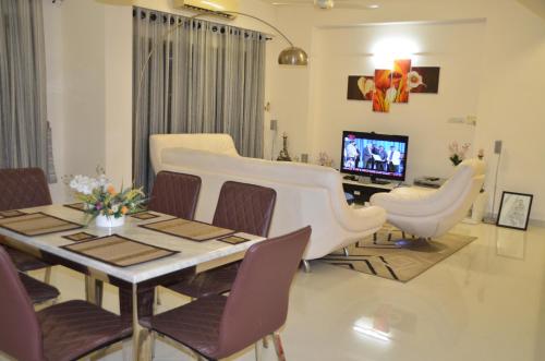 a living room with a table and chairs and a television at Atrium - ICONIC APARTMENT in Sri Jayewardenepura Kotte