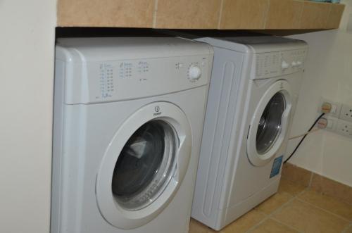 a washing machine and a dryer in a kitchen at Atrium - ICONIC APARTMENT in Sri Jayewardenepura Kotte