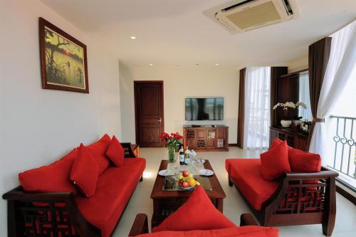 a living room with a red couch and a table at Cuu Long Hotel in My Tho