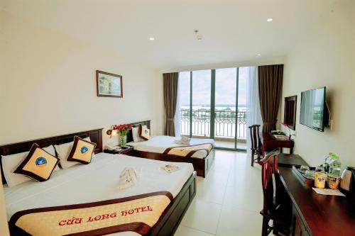a hotel room with two beds and a balcony at Cuu Long Hotel in My Tho