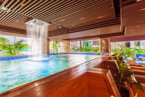 a swimming pool in a building with a large window at Harmony Saigon Hotel & Spa in Ho Chi Minh City