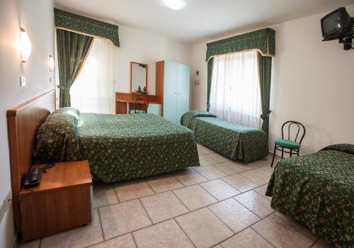 una camera d'albergo con due letti e un tavolo di Hotel Garden a Giulianova