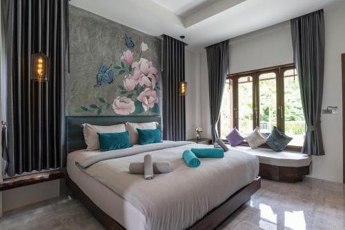 a bedroom with a large bed with blue pillows at Na Vela Village in Ko Lanta