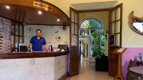 a man standing in front of a counter in a restaurant at Hotel Santa Ana in Mérida