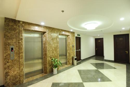 a lobby with glass elevators and a potted plant at Cuu Long Hotel in My Tho