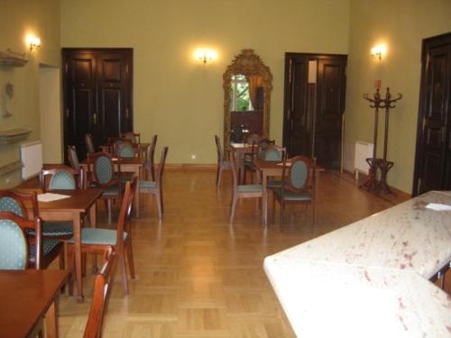 jadalnia z drewnianymi stołami i krzesłami w obiekcie Linat Orchim Dom Gościnny w Łodzi