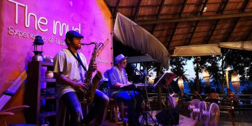 a group of people playing music in a restaurant at The Mud - Eco Hotel in Ban Bang Po
