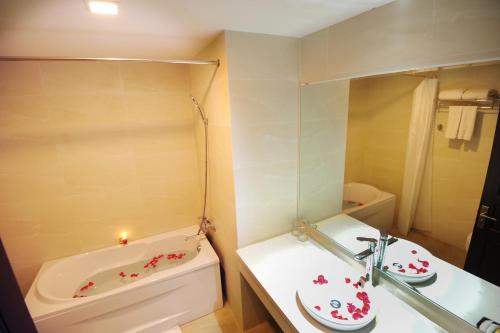 a bathroom with a bath tub and a sink and a bath tub at Cuu Long Hotel in My Tho