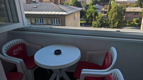 a white table and chairs in a room with a window at Apartman centar lux in Tuzla