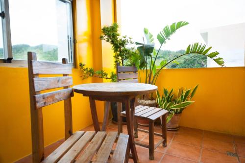 a table and chairs in a room with a window at Kenting Shen's Homestay in Eluan