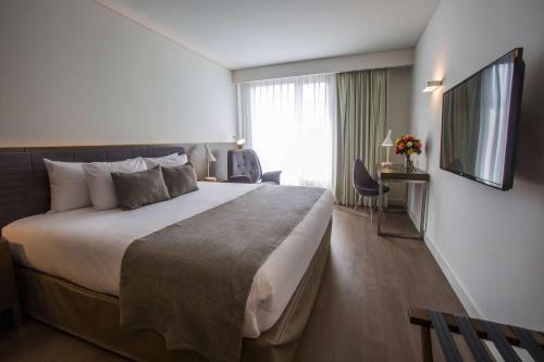 a hotel room with a large bed and a television at Dazzler by Wyndham Lima San Isidro in Lima