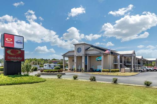 a hotel with a sign in front of a parking lot at Suburban Studios at the University in Conway