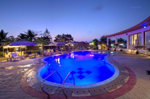 a swimming pool in a resort at night at Beira Mar Beach Resort in Benaulim