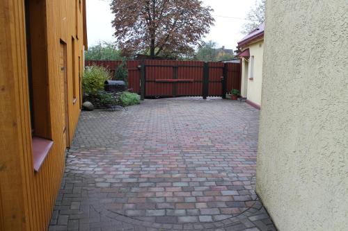 a brick driveway with a fence in a yard at Amrai in Ventspils