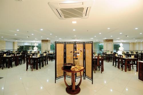 a dining room with tables and chairs in a room with a unintention at Cuu Long Hotel in My Tho