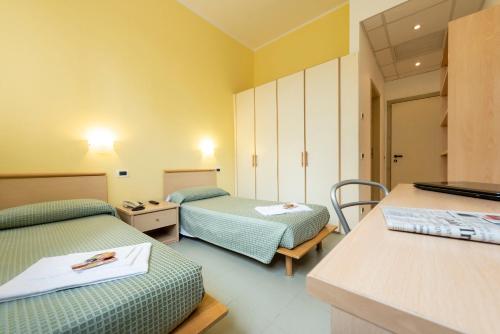 a hospital room with two beds and a desk at Casa per Ferie Opera Don Calabria in Rome