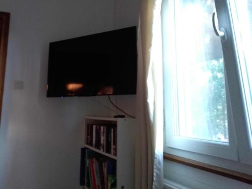 a flat screen tv on a wall next to a window at Haus Polly in Strasshof an der Nordbahn