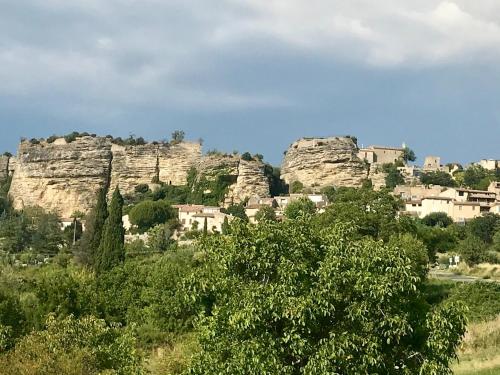 a mountain village with dwellings on top of it at À l'étape des randonneurs in Saignon