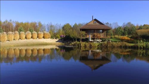 a house sitting on the shore of a lake at Mikalojiškis in Inturkė