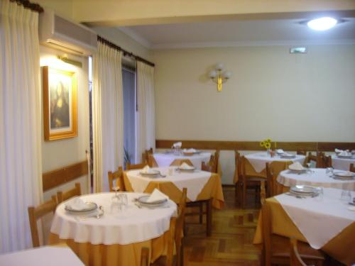 ein Esszimmer mit weißen Tischen und Stühlen in der Unterkunft Hotel Peninsular in Caldelas