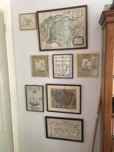 a wall with a bunch of framed maps on it at Pied à Terre Oostersingel UMCG in Groningen