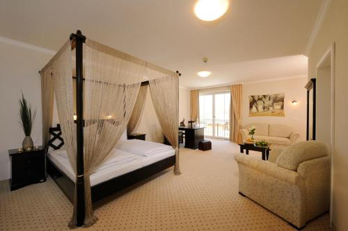 una camera con letto a baldacchino e sedia di Hotel Inspiration Garni a Tittmoning