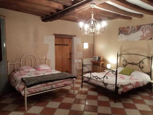 une chambre avec deux lits et un lustre dans l'établissement The peaceful countryside corner, à Mazé